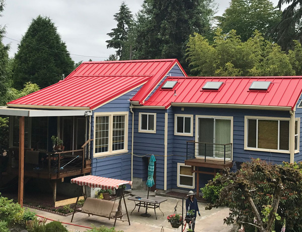 roof-repair-energy-efficiency a blue exterior home with bright red metal roofs